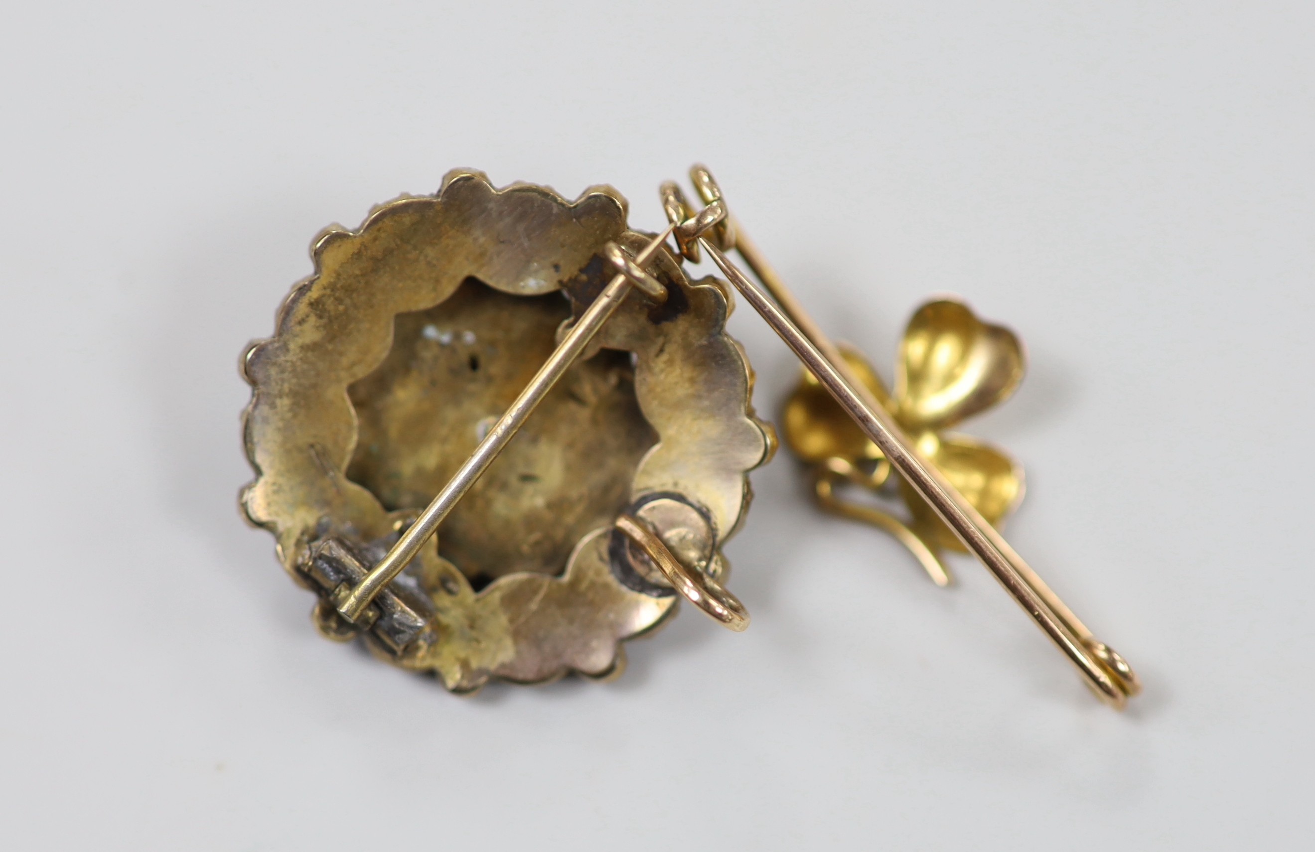 A yellow metal 'shamrock' bar brooch, 36mm, 1.6 grams and a late Victorian gilt white metal and garnet cluster set pendant brooch.